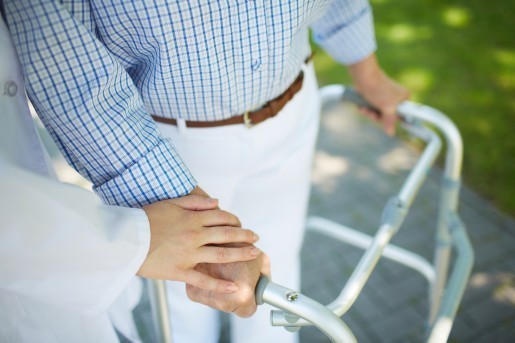 Close-up of clinician hand on that of disabled woman