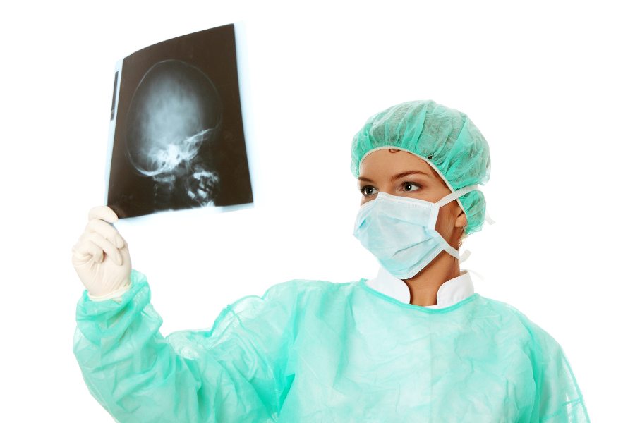 Female doctor examining a head x-ray photo scan. Isolated on white
